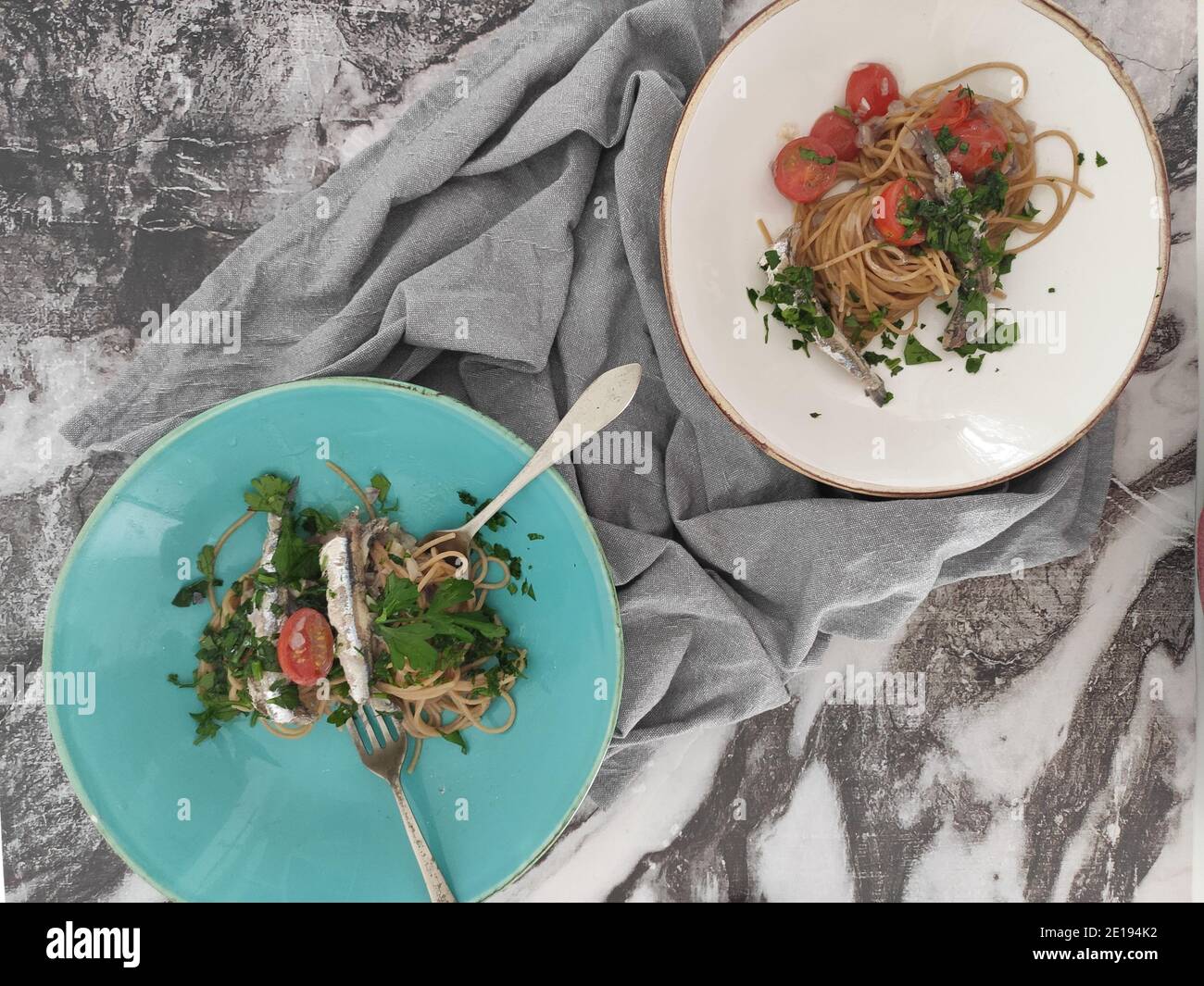 Ciotole di pasta italiana con sardine, pomodori ciliegini e persil fresco Foto Stock