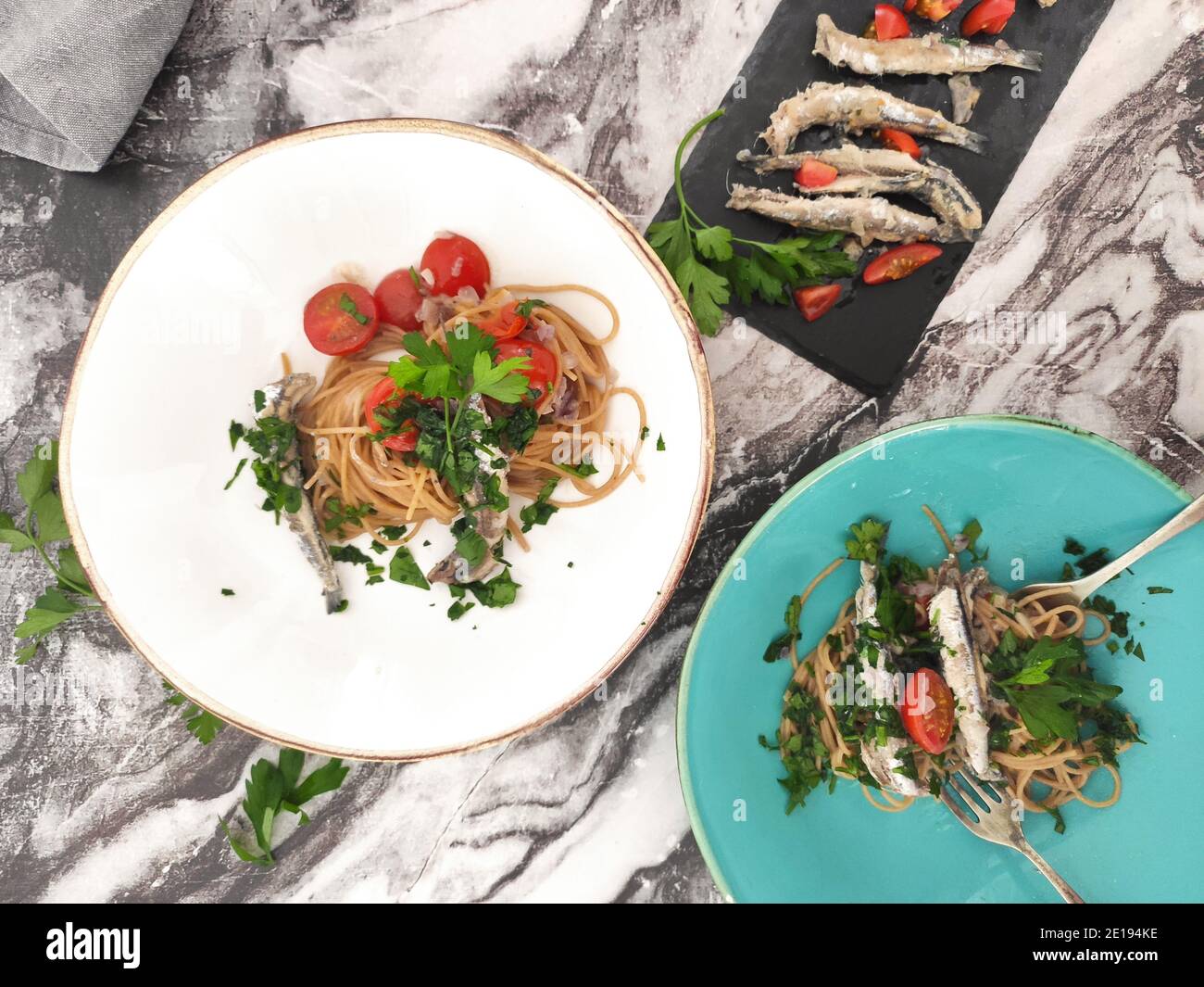 Ciotole di pasta italiana con sardine, pomodori ciliegini e persil fresco Foto Stock