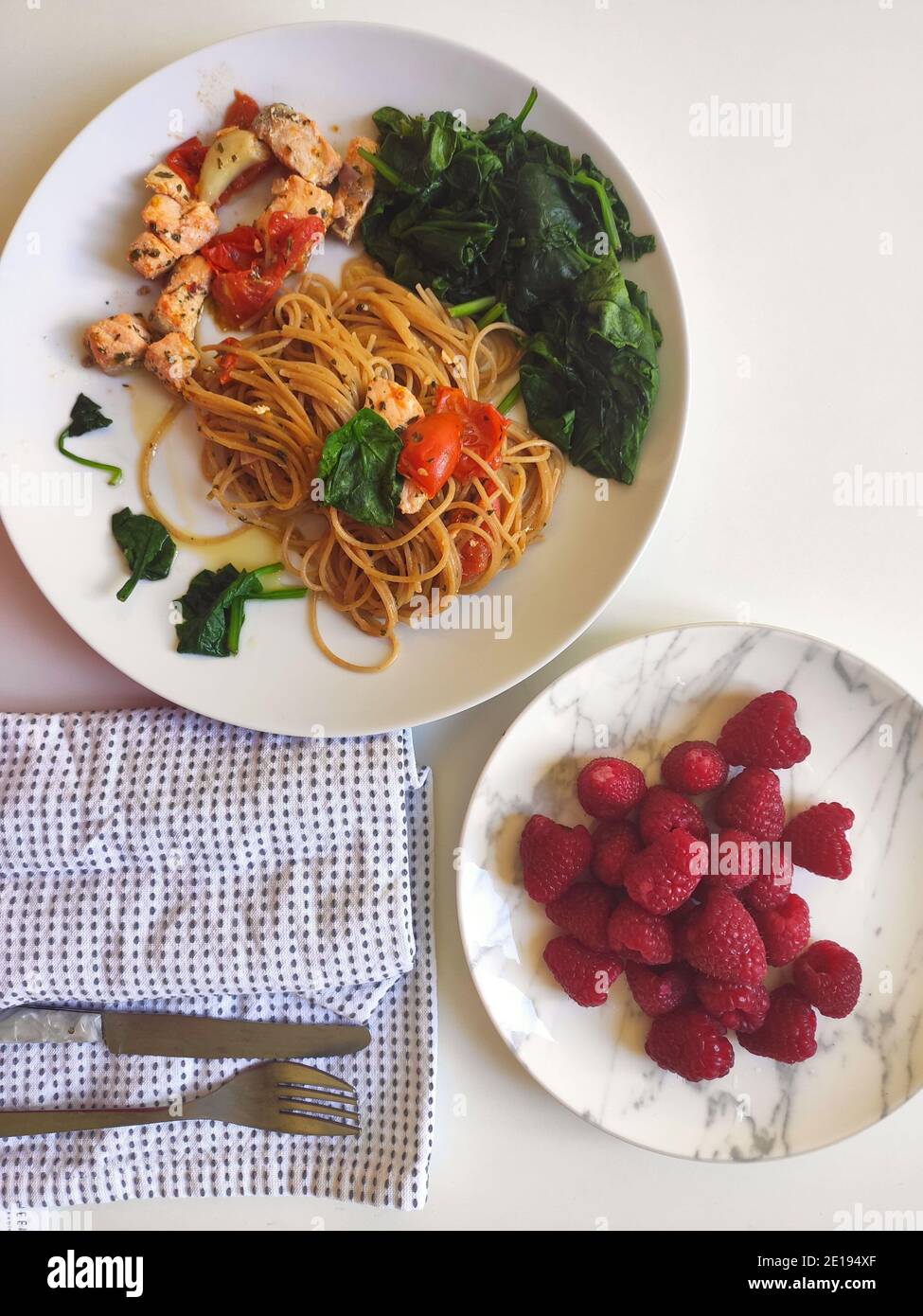 Spinaci e spaghetti al salmone in una ciotola bianca Foto Stock