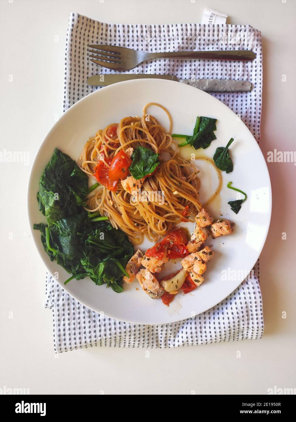 Spinaci e spaghetti al salmone in una ciotola bianca Foto Stock