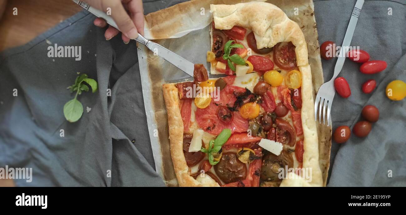 Pizza fatta in casa con pomodori freschi e un po' di basilico Foto Stock