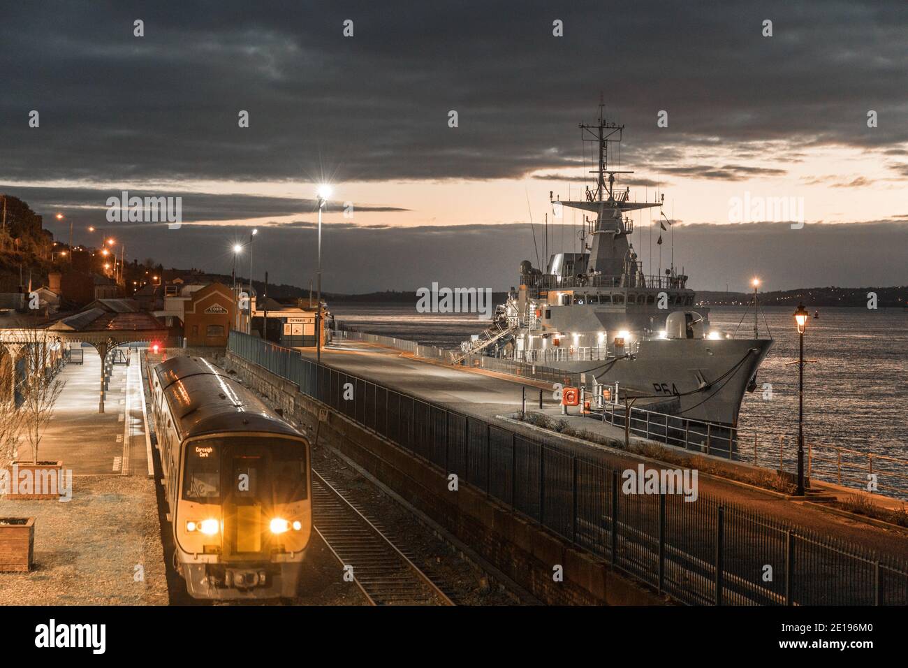 Cobh, Cork, Irlanda. 05 gennaio 2021. Nave navale irlandese LÉ George Bernard Shaw all'ormeggio di acque profonde prima dell'alba, come un treno di mattina presto lascia la stazione a Cobh, Co. Cork, Irlanda. - credito; David Creedon / Alamy Live News Foto Stock