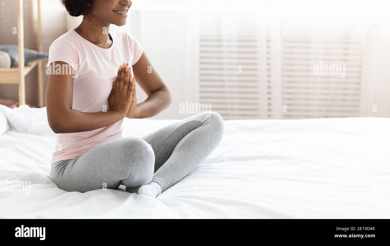 Corto di donna nera in pigiama che pratica yoga a casa Foto Stock