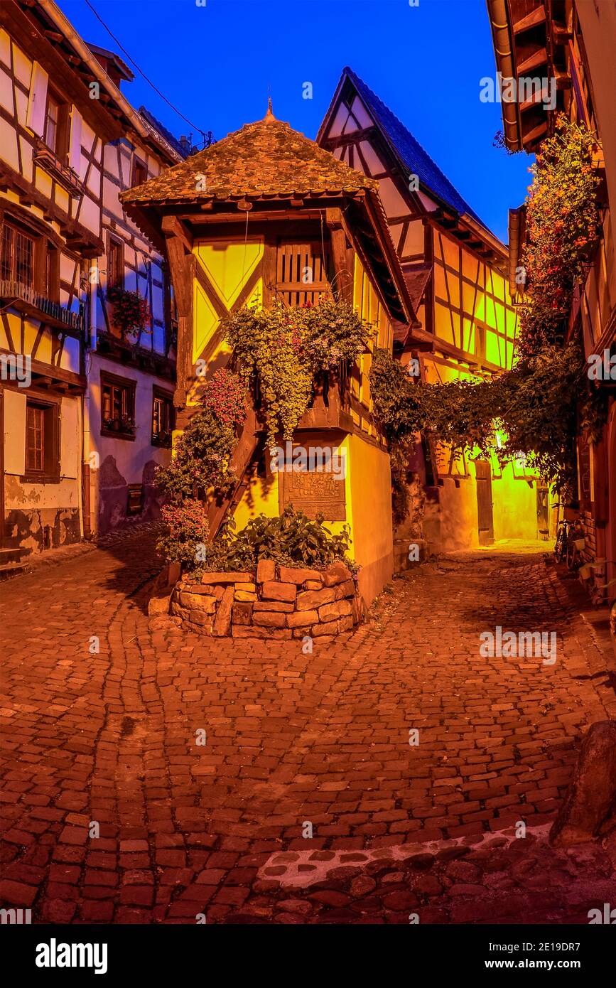 Il piccolo villaggio feudale di Eguisheim durante l'ora blu. Foto scattata il 10 agosto 2019 nella regione dell'Alsazia in Francia. Foto Stock