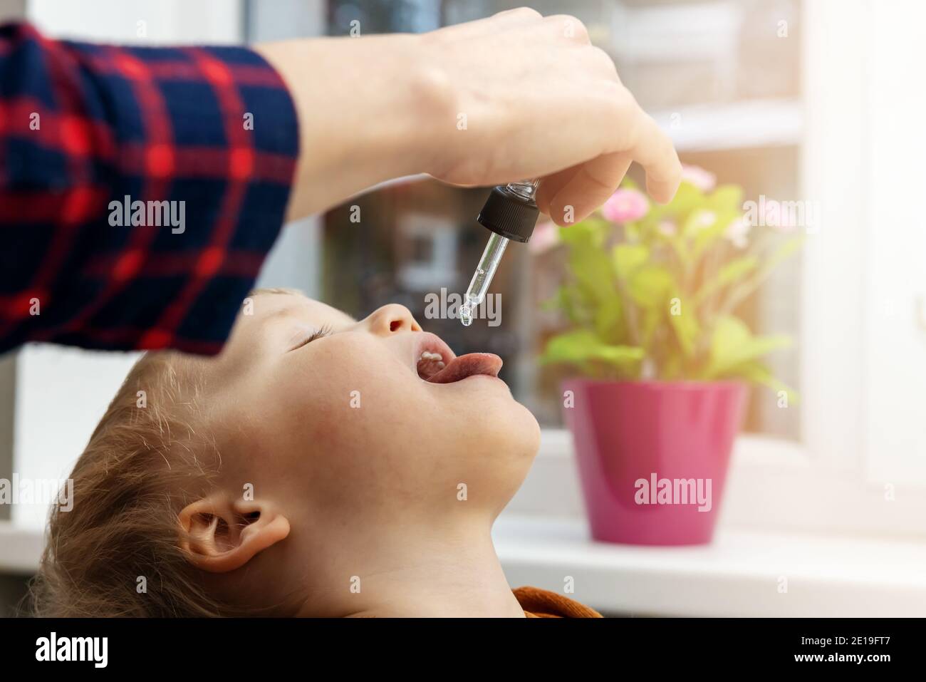 madre che dà gocce di vitamina con contagocce al suo bambino. integratori alimentari per i bambini Foto Stock