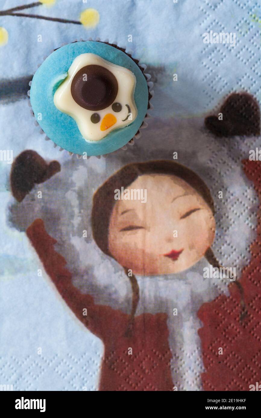 Torta di coppe Snowman da scatola di M&S 9 mini Festive cupcakes set su Natale serviette tovagliolo Xmas con la ragazza tenere le mani in alto Foto Stock