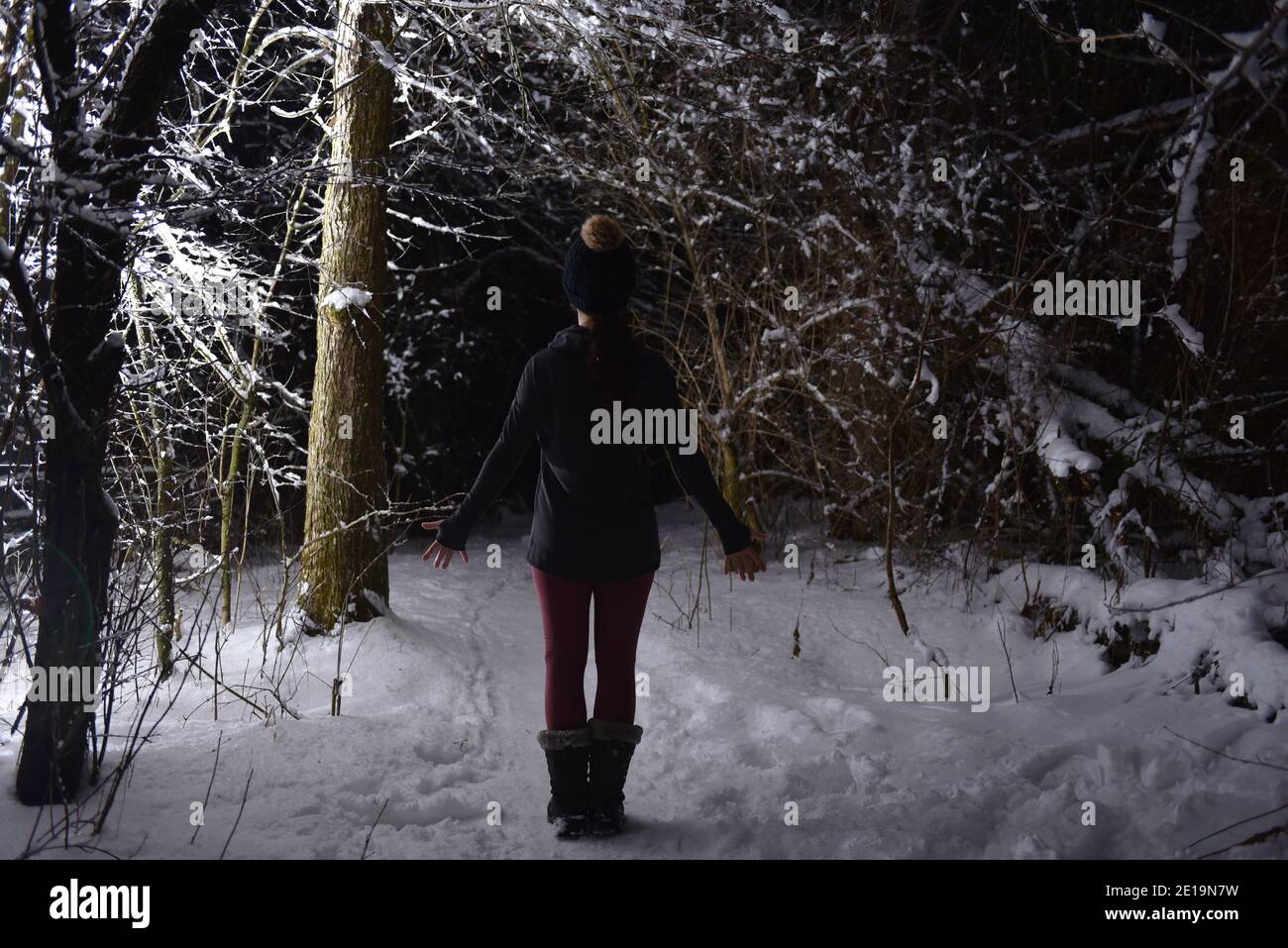 Praticare yoga in inverno, nella foresta di notte nella neve. Nuove sfide con neve e freddo vi insegnano come raggiungere la messa a fuoco e il controllo. Foto Stock