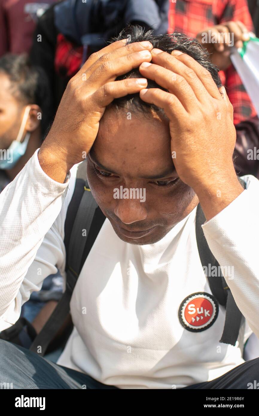 Un lavoratore migrante attende al di fuori del Ministero degli Affari Esteri qualsiasi forma di comunicazione durante la manifestazione.centinaia di lavoratori migranti del Bangladesh scontenti hanno dimostrato al di fuori del Ministero degli Affari Esteri chiedendo un'azione urgente da parte del governo per facilitare il loro ritorno alle loro destinazioni di lavoro in Medio Oriente. Foto Stock
