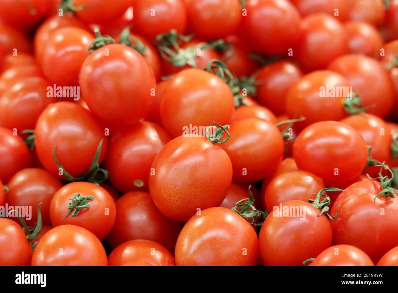 Pomodori ciliegini rossi con taglio verde, verdure fresche sul mercato Foto Stock