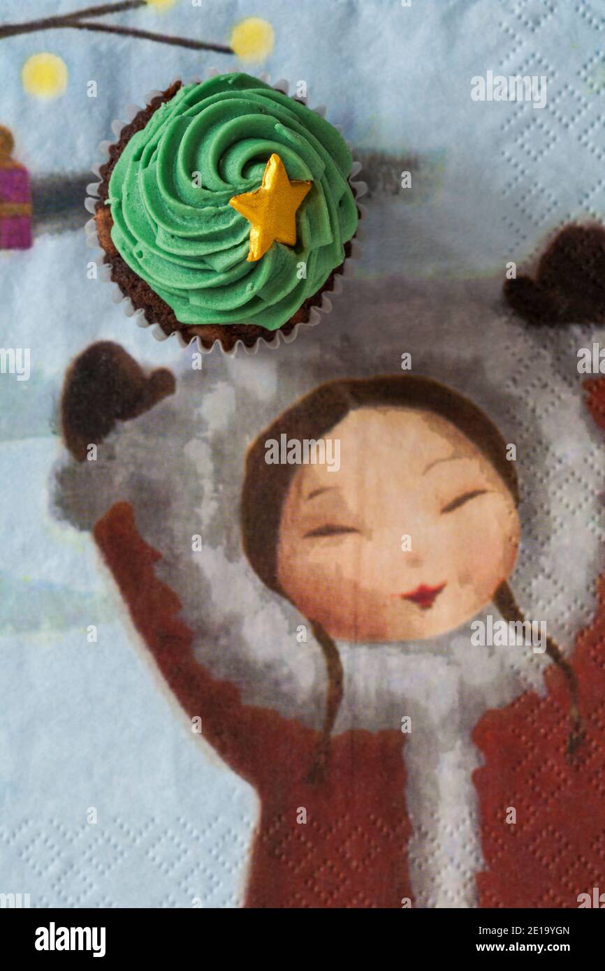 Albero di Natale con torta cuppake stella oro da scatola Di M&S mini cupcakes festivo impostato su tovagliolo serviette di Natale Natale con la ragazza che tiene le mani in su Foto Stock