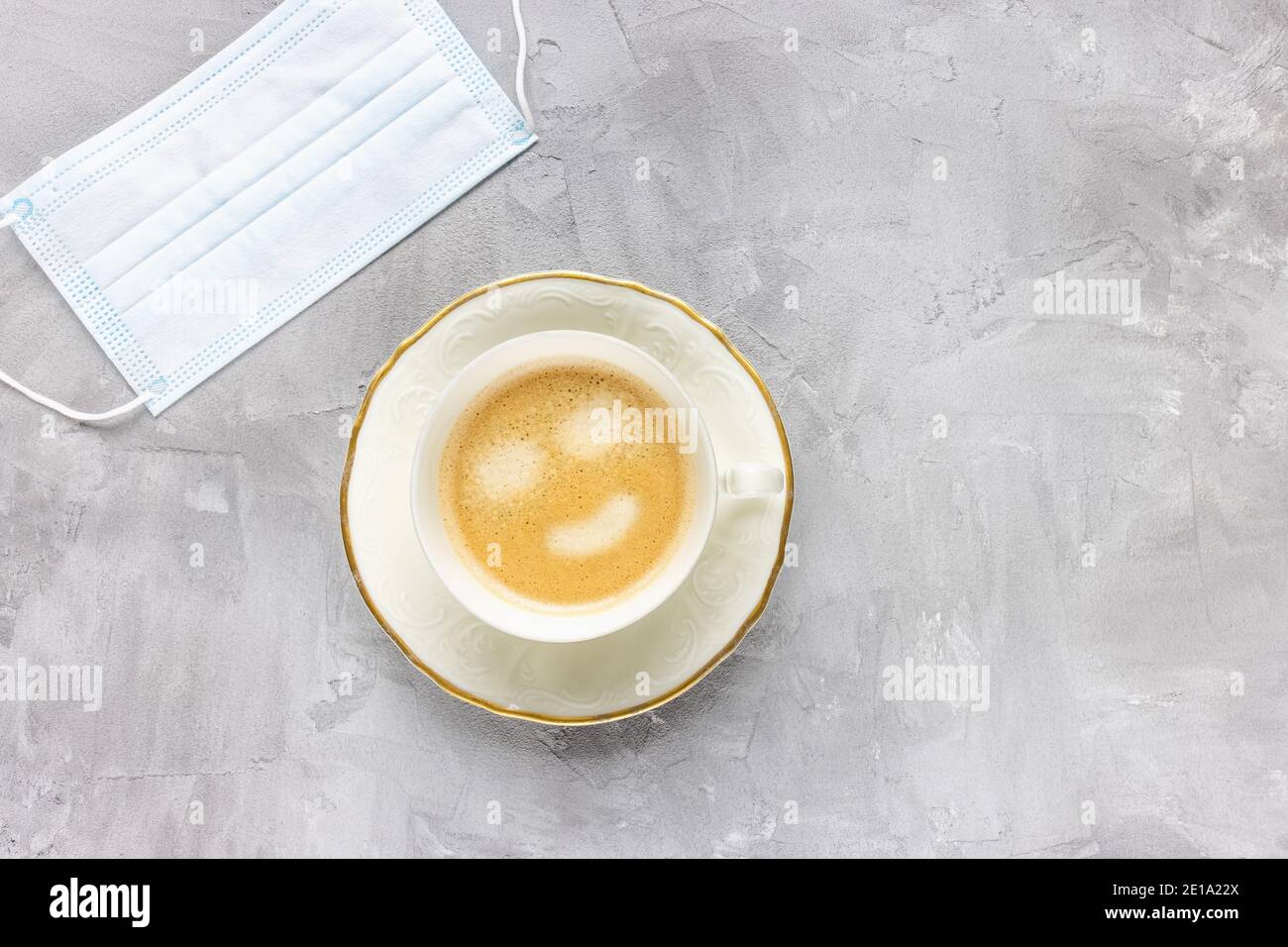 Maschera medica bianca e tazza di caffè Foto Stock