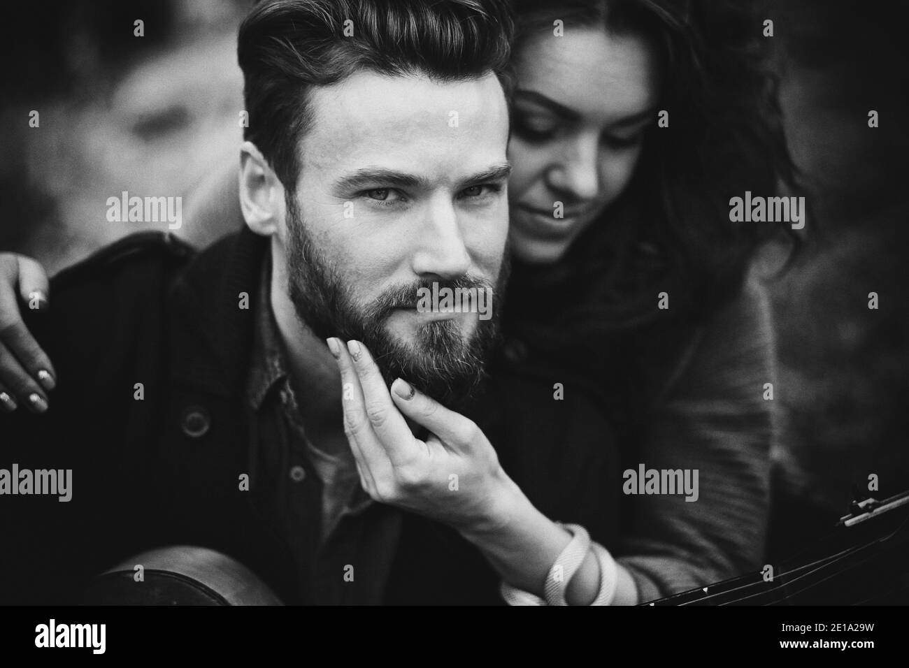 foto in bianco e nero di una coppia caucasica innamorata nella natura autunnale. L'uomo giovane e la donna maledetta si abbracciano sulla riva di un lago Foto Stock