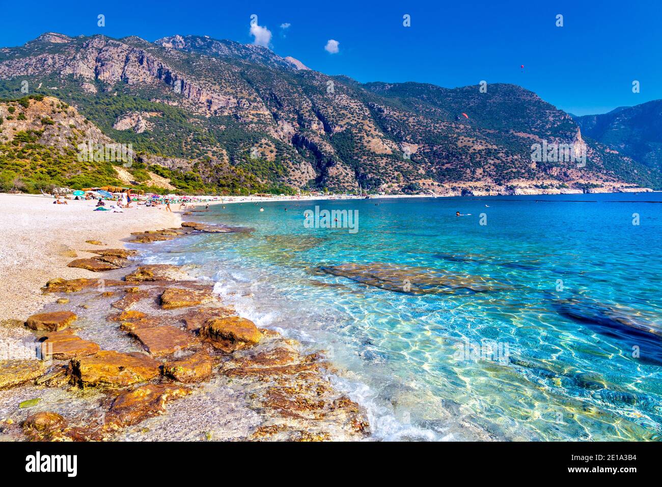 Acque azzurre e spiaggia di ciottoli a Oludeniz, Riviera Turca, Turchia Foto Stock