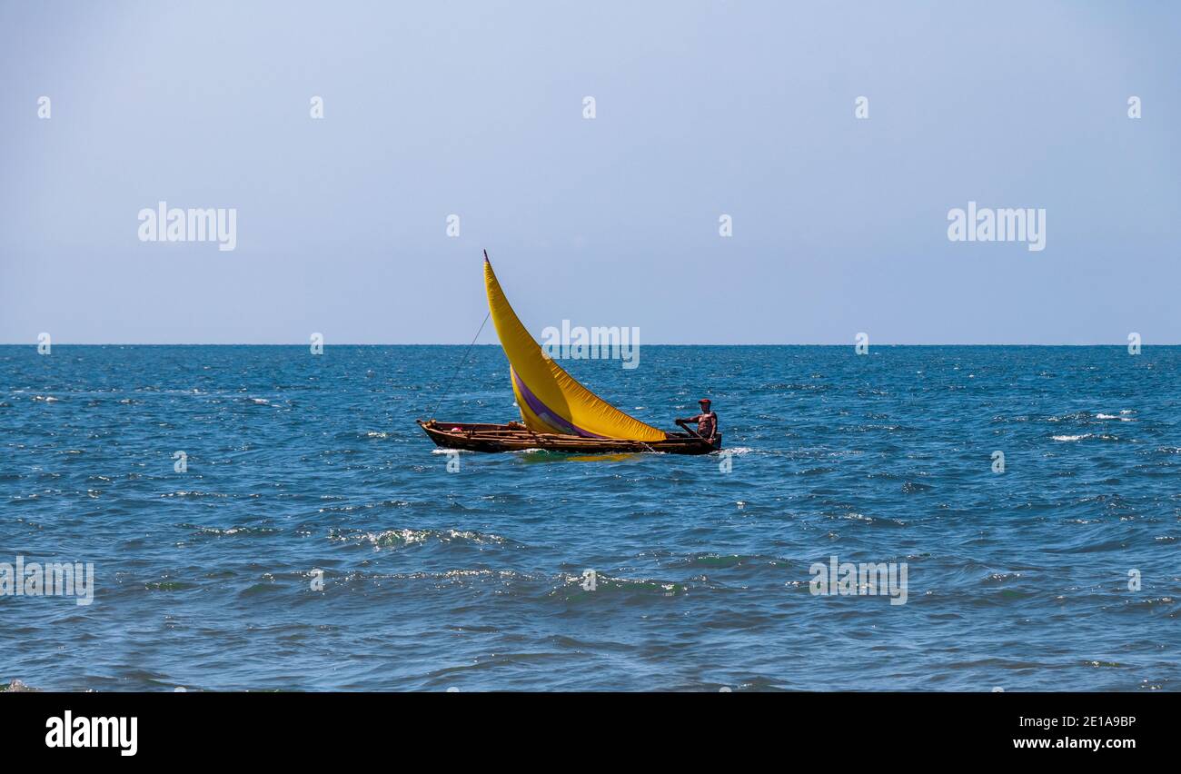 Una barca a vela da sola nel mezzo di un enorme oceano pacifico, innalzando  le sue vele colorate per consentire al vento di dare la sua energia dolce  Foto stock - Alamy