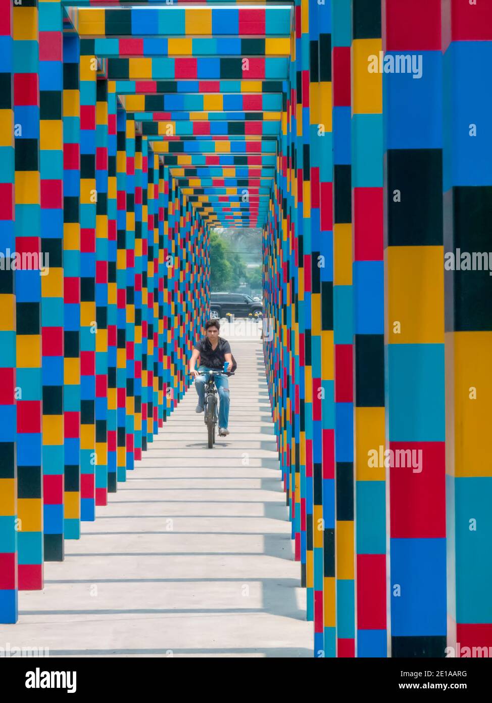 Uomo in bicicletta nel colorato tunnel, Polanco, Città del Messico, Messico Foto Stock