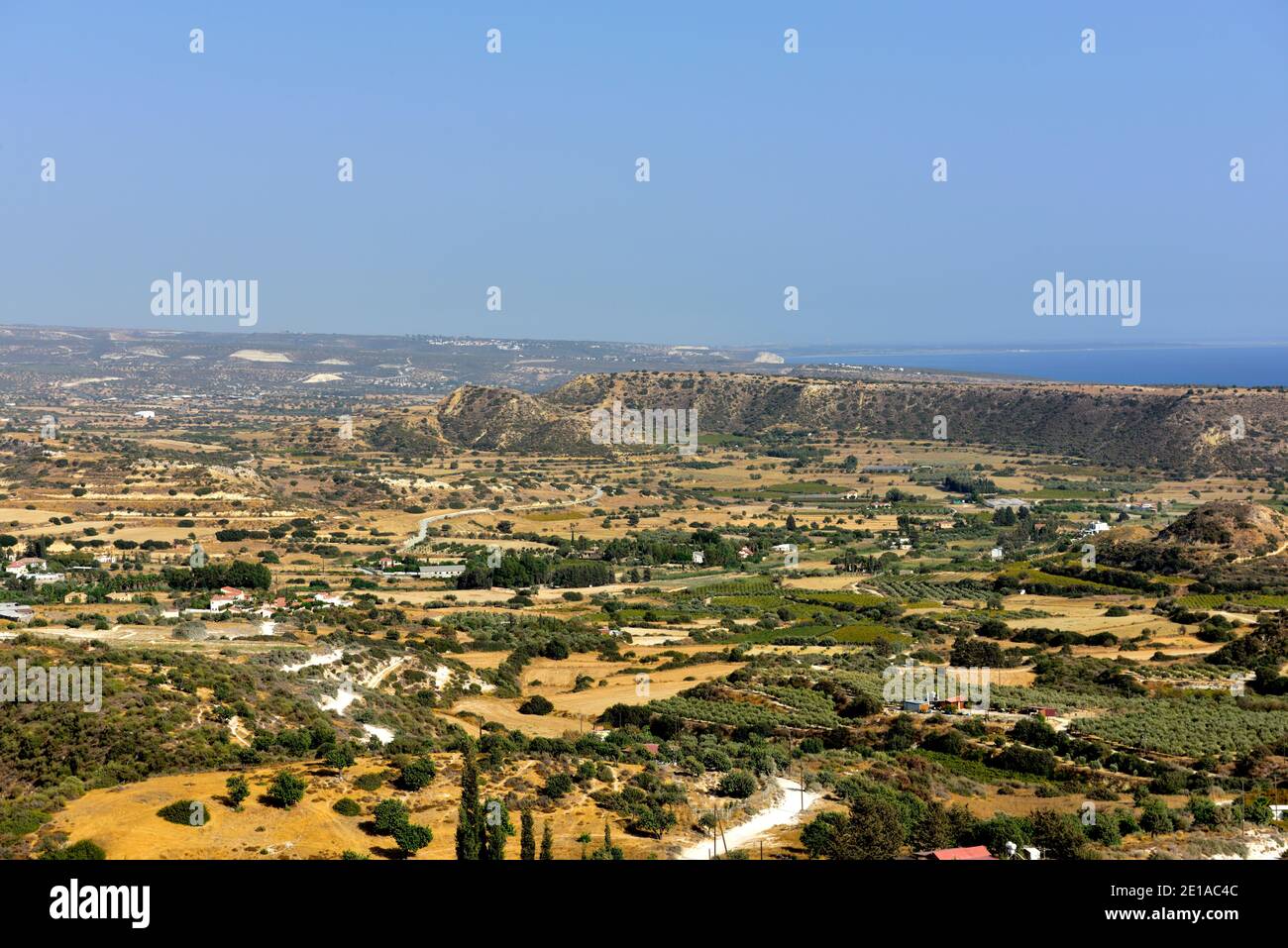 Ampia vista del paesaggio interno di Cipro con il Mar Mediterraneo in lontananza, la regione Pissouri con case sparse e colline Foto Stock