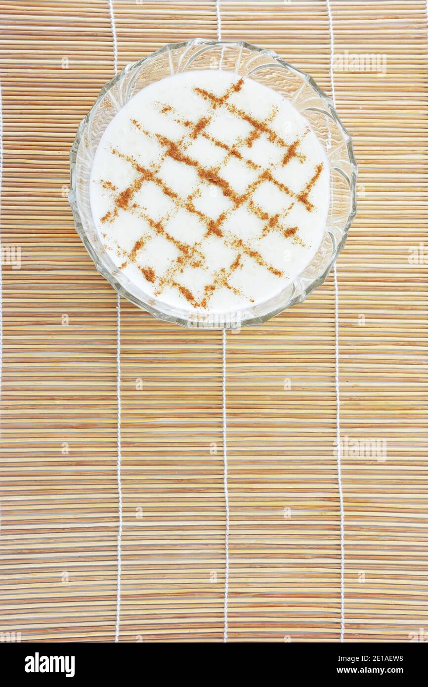 Riso alla cannella pudding riso pudding su bambù paglia stuoia come sfondo Foto Stock