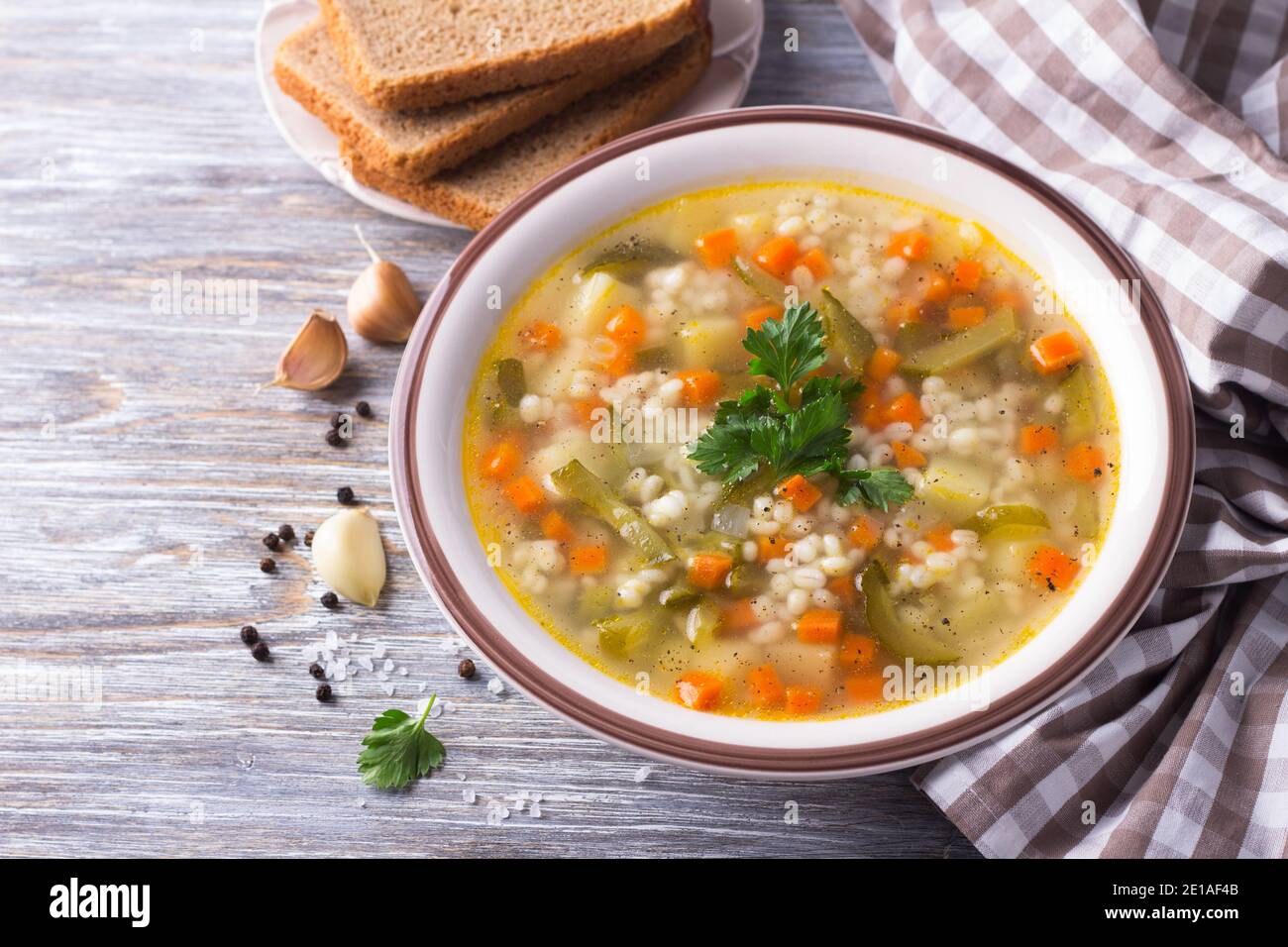 Zuppa vegana con cetrioli sottaceto e orzo perlato, rassolnik. Cucina tradizionale russa fatta in casa. Su un tavolo di legno Foto Stock