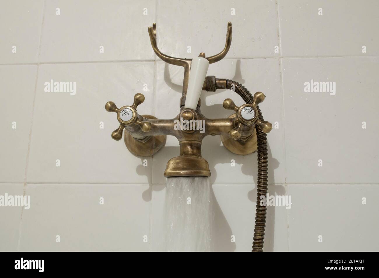 Aprire il rubinetto del tubo del bagno in rame antico. Getto d'acqua Foto Stock