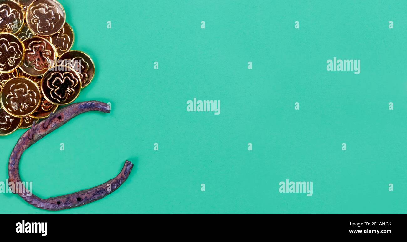 St Patricks giorno Irlandese buona fortuna Horse scarpe e oro monete su sfondo di carta verde con spazio per la copia Foto Stock