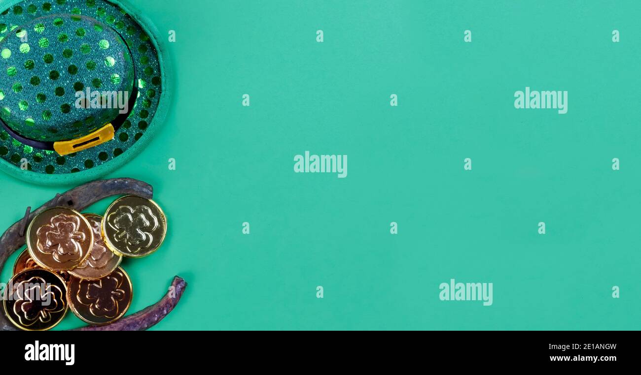 Festa di festa di San Patrizio con elfo irlandese, scarpe da cavallo e monete d'oro su sfondo di carta verde con spazio per la copia Foto Stock