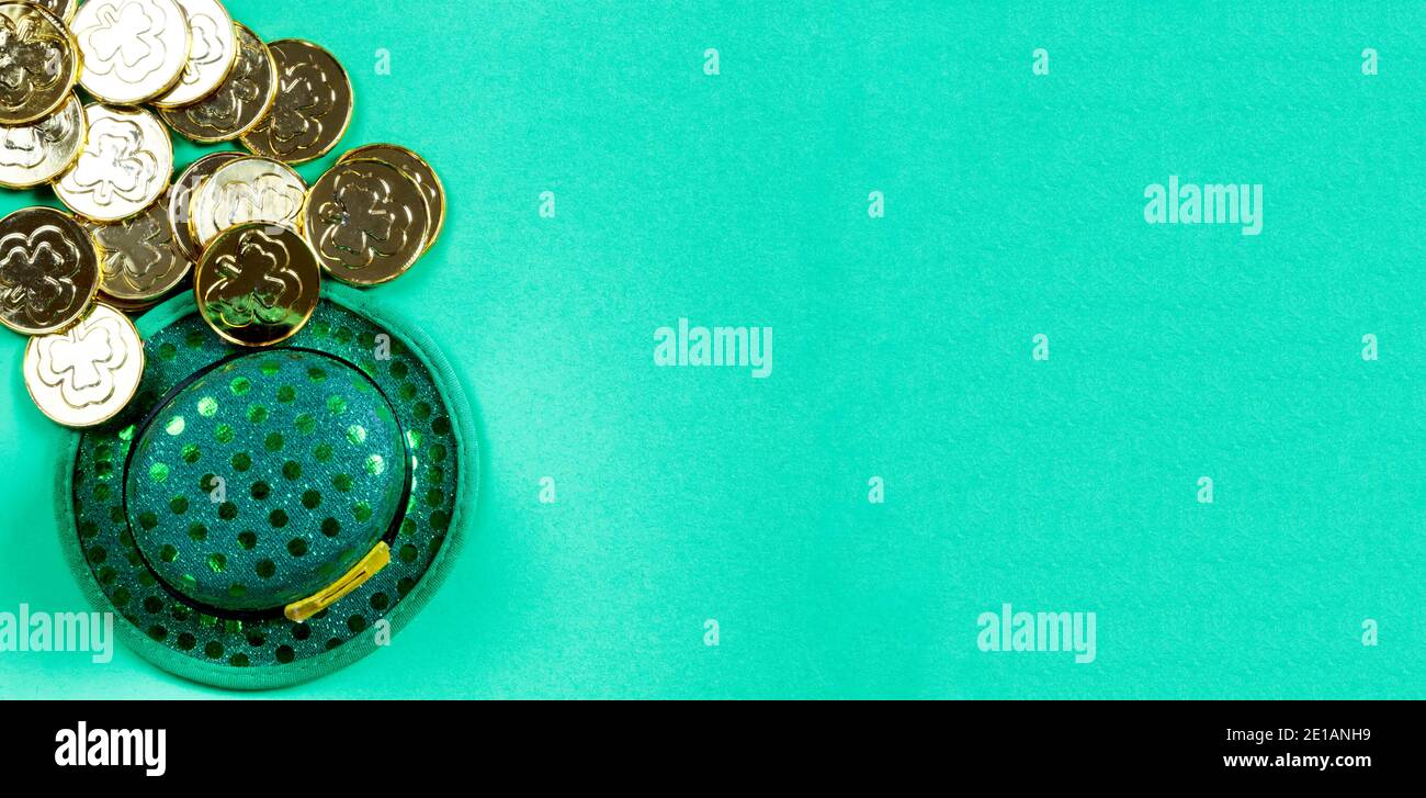 Cappello irlandese di giorno di San Patrizio e monete d'oro su sfondo verde con spazio per la copia Foto Stock