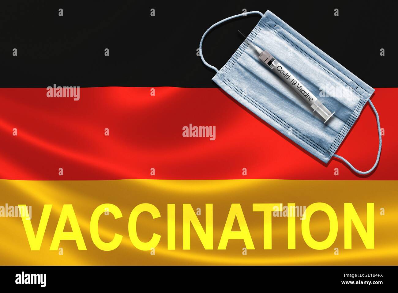 COVID-19 vaccinazioni in Germania Concept con maschera facciale e siringa di vaccino ad ago sulla bandiera tedesca. Foto Stock