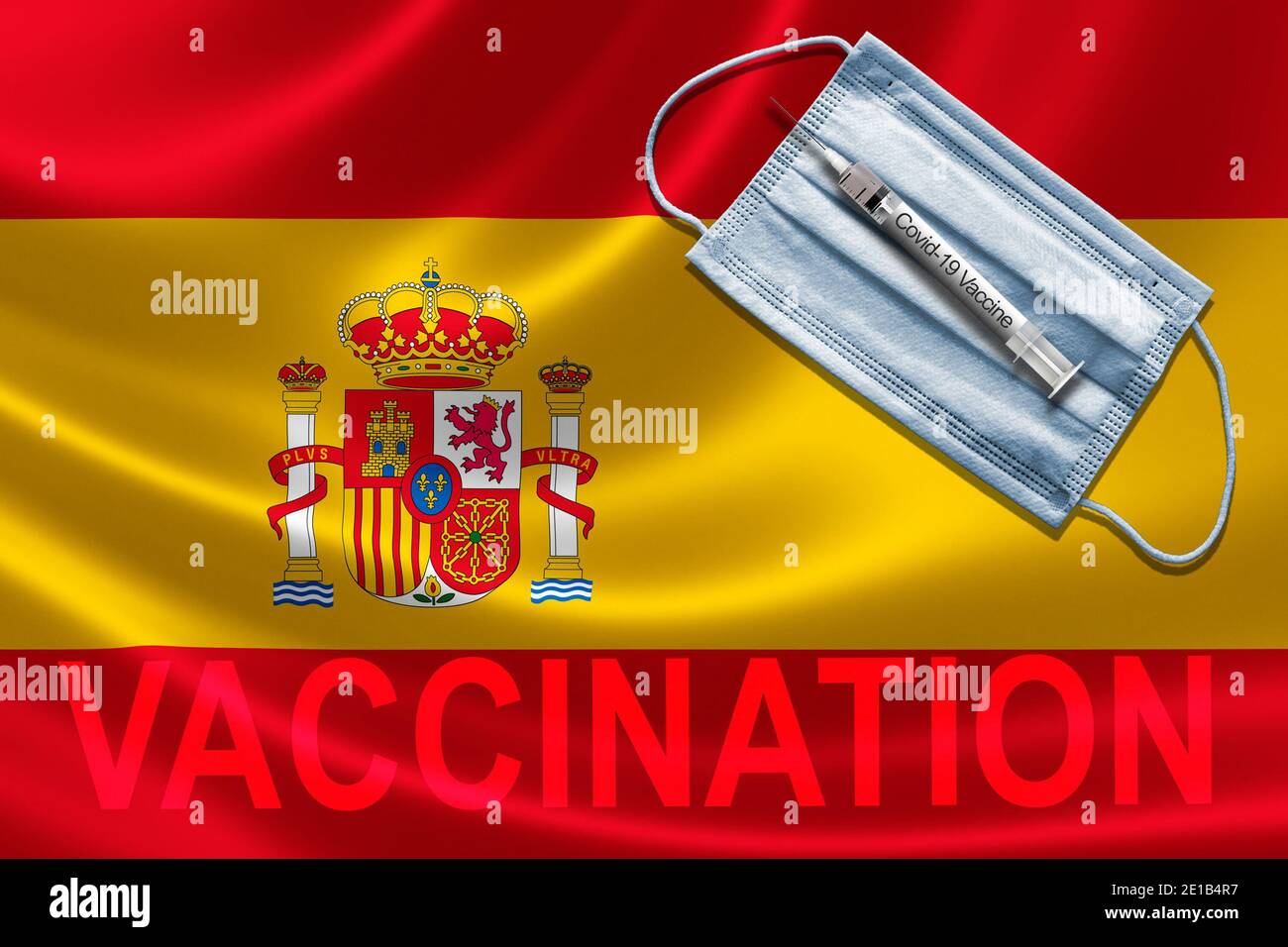 COVID-19 vaccinazioni in Spagna Concept con maschera facciale e siringa di vaccino ad ago sulla bandiera spagnola. Foto Stock