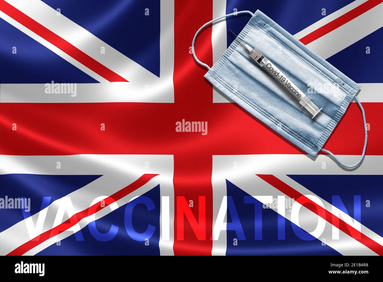 Vaccino COVID-19 in UK Concept con maschera facciale e siringa di vaccino ad ago su British Flag. Foto Stock