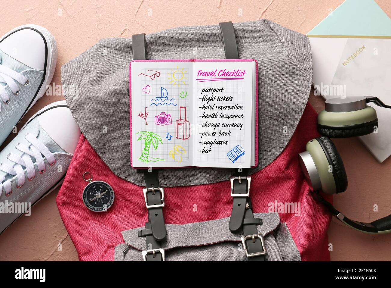 Notebook con lista di controllo delle cose da fare prima di viaggiare e. zaino su sfondo a colori Foto Stock