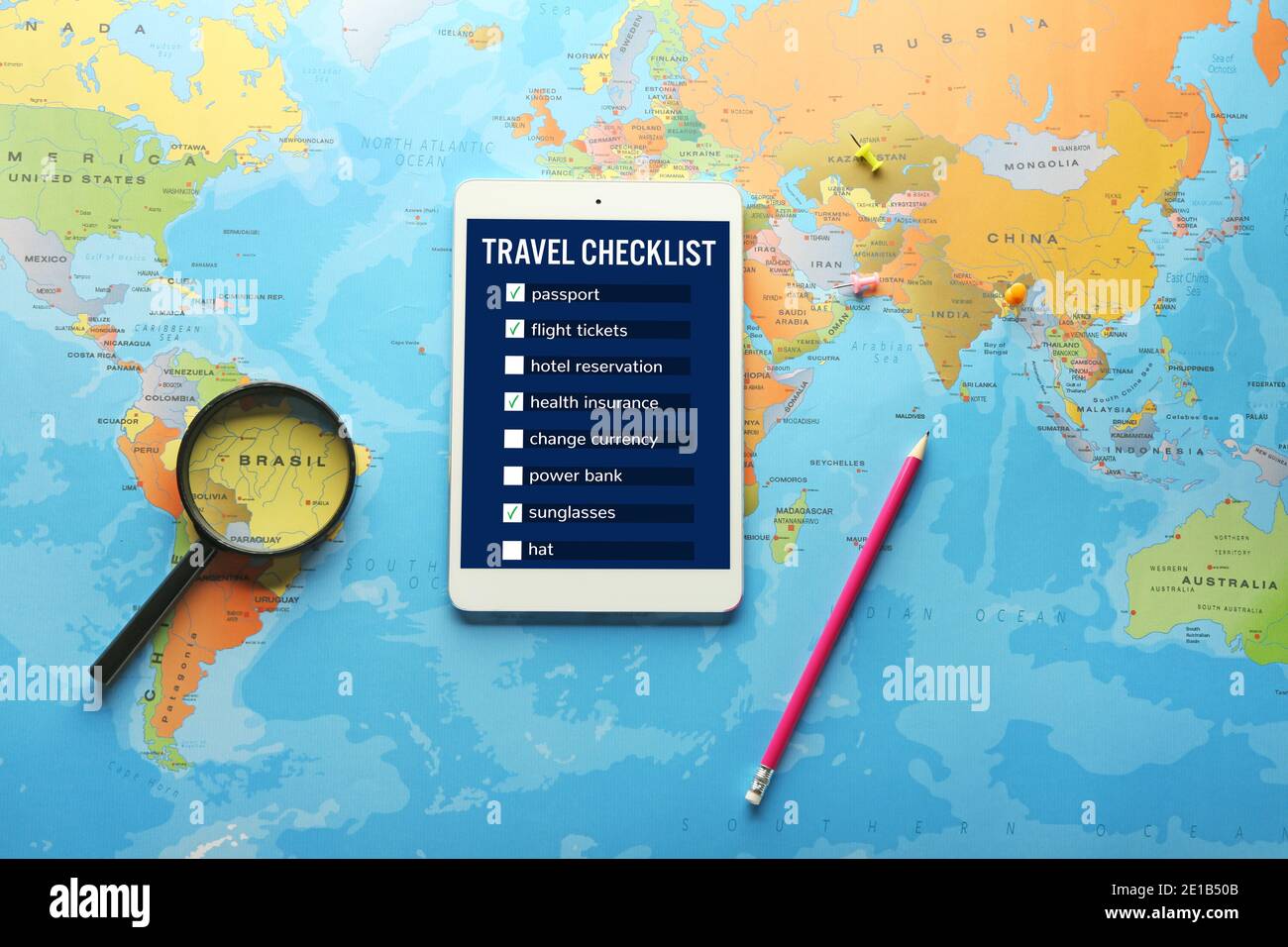 Tablet con un elenco di controllo delle operazioni da eseguire prima viaggiare sullo schermo e sulla mappa del mondo Foto Stock