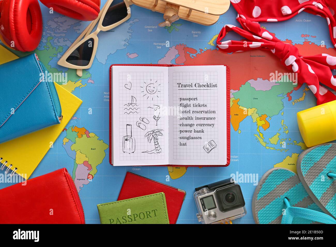 Notebook con elenco di controllo delle operazioni da eseguire prima di viaggiare sulla mappa del mondo Foto Stock
