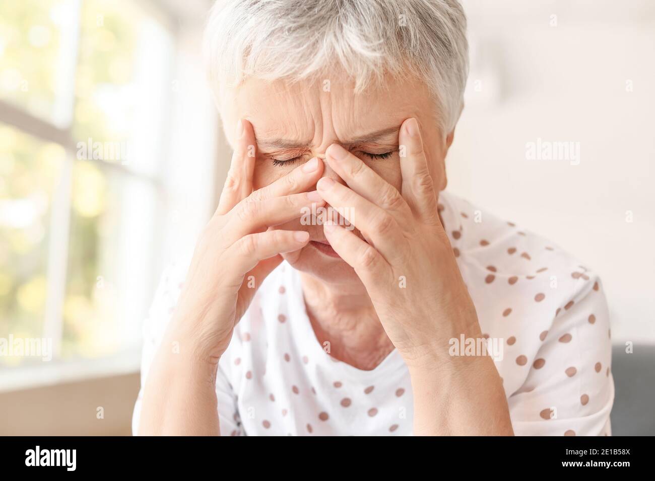 Donna anziana stressata che soffre di mal di testa Foto Stock