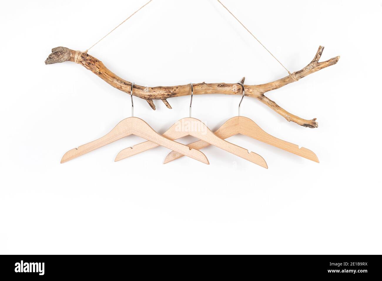 Tre appendiabiti su un bastone di legno spesso, grande design per qualsiasi scopo. Concept Eco-friendly Case o vendita stagione. Vista frontale. Foto Stock