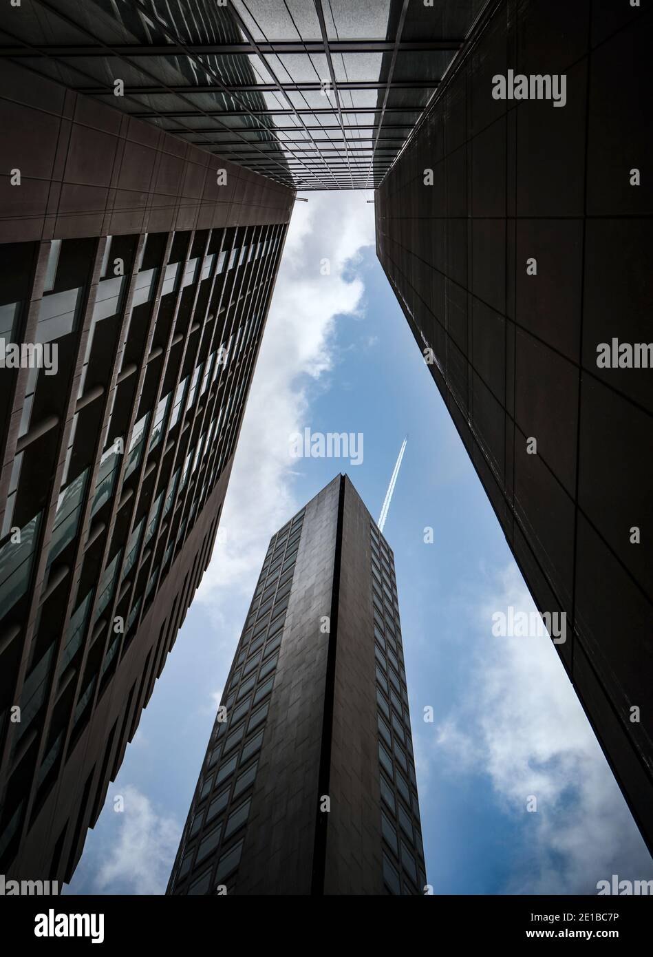 Il suggestivo edificio a torre Alpha che guarda in su il cielo jumbo jet pista aereo sopra il settore commerciale paesaggio urbano A Birmingham, Regno Unito Foto Stock