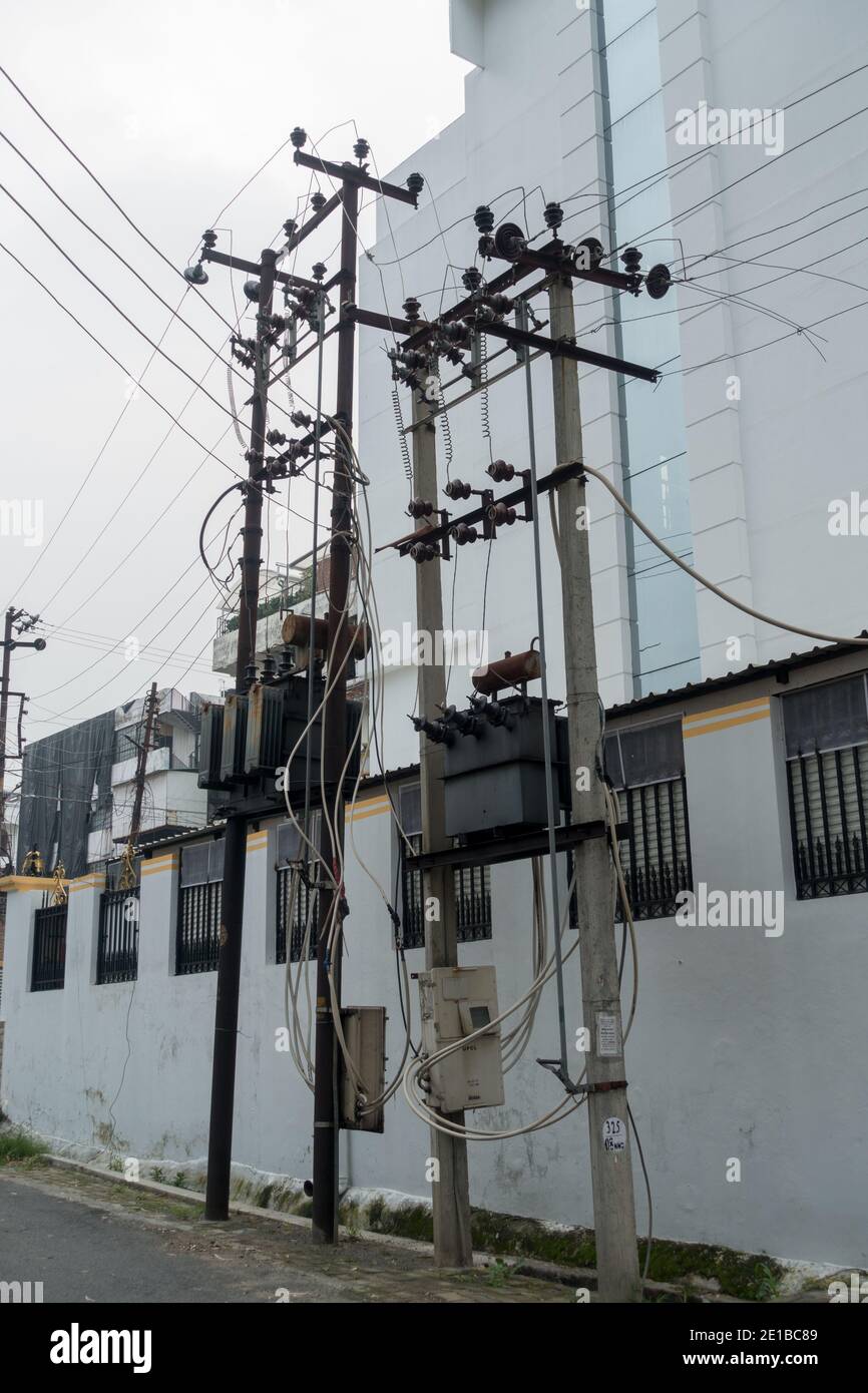 Pali elettrici con trasformatori in alto in India. Foto Stock