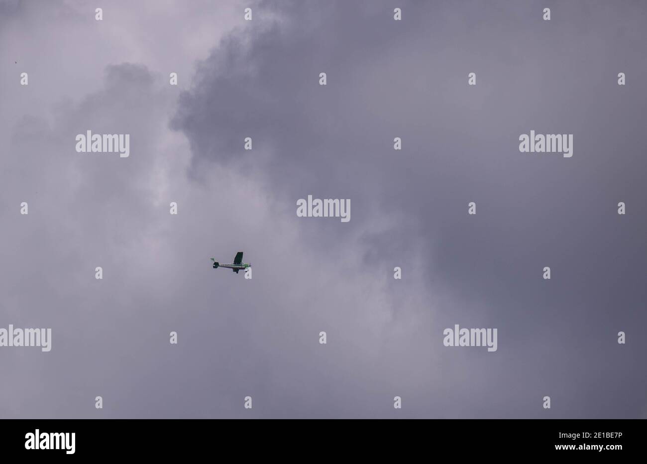 Johannesburg, Sudafrica - un piccolo aereo isolato in volo in un cielo tempestoso sopra la città Foto Stock