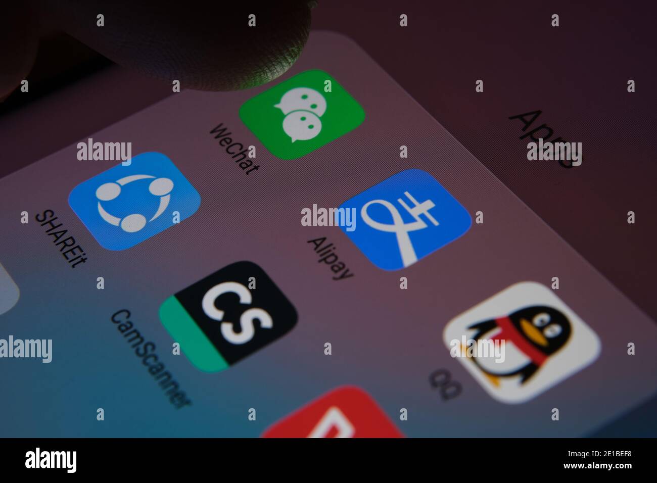 Stafford, Regno Unito - 6 gennaio 2021: Alipay, WeChat, QQ, ShareIt, CamScanner, WPS Office app visualizzate sullo schermo e un dito sfocato sulla parte superiore Foto Stock