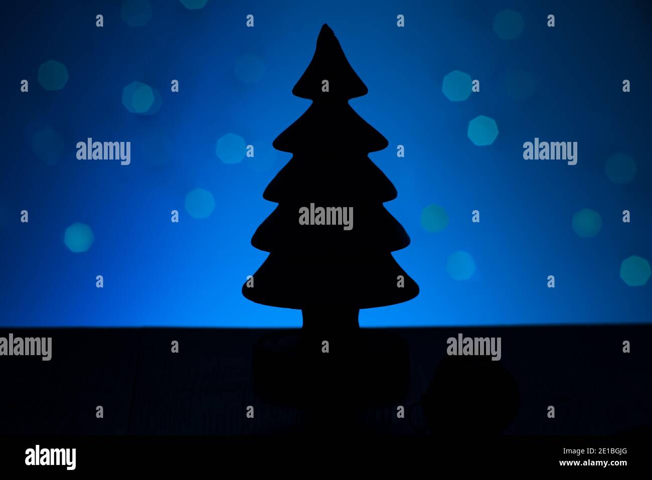 Albero di Natale silhouette ombra isolato su sfondo blu cielo con stelle bokeh. Momento magico. Foto Stock
