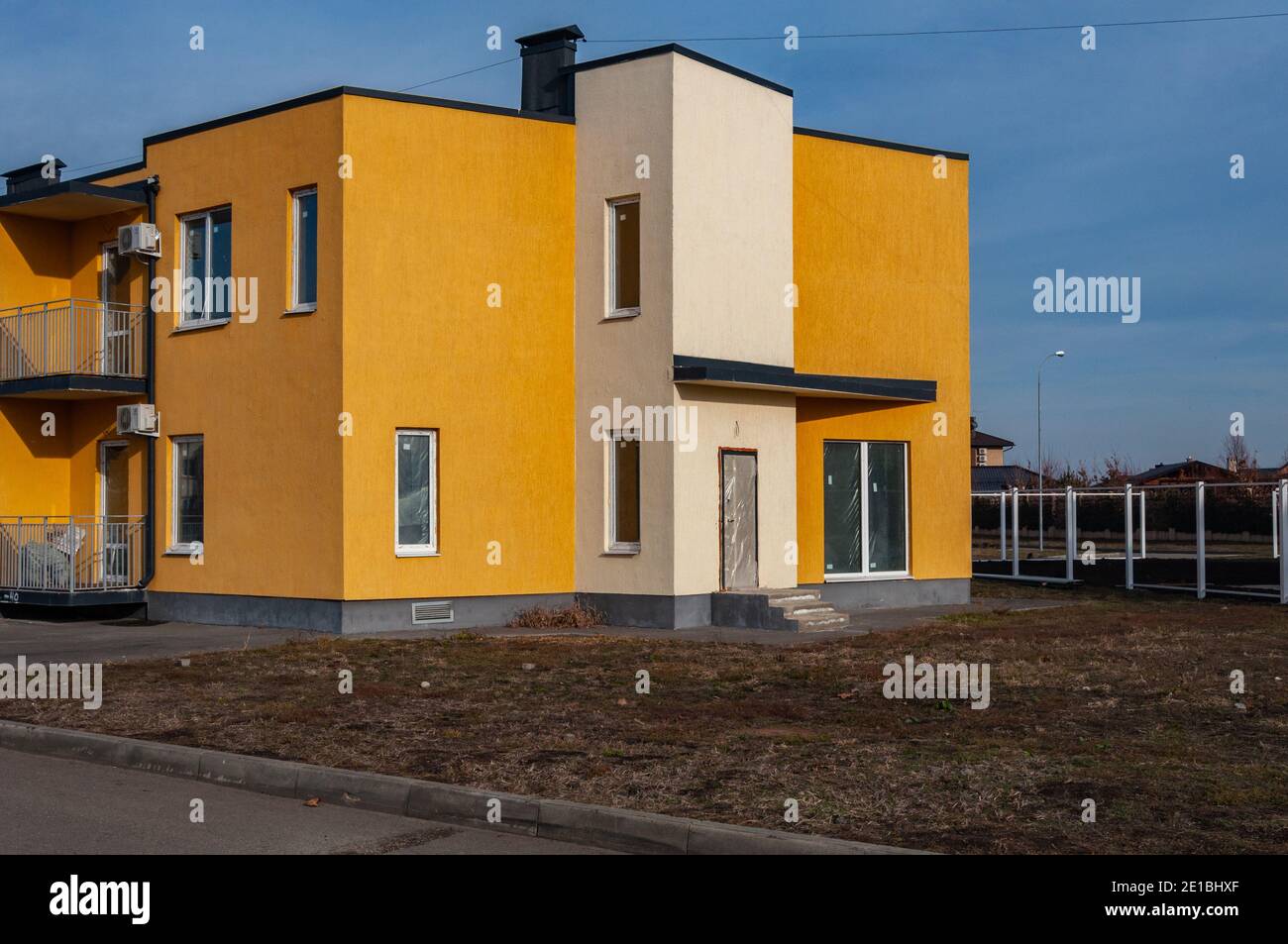 Krasnodar, Russia - 5 gennaio 2021: Moderno edificio di appartamenti a due piani con tetto piatto e finestre strette. Foto Stock