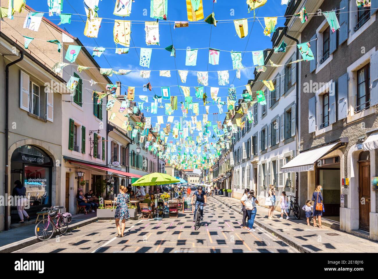 Le persone che godono di caffè e negozi sul marciapiede in St Joseph Street, nella piccola città di Carouge al confine con Ginevra. Foto Stock