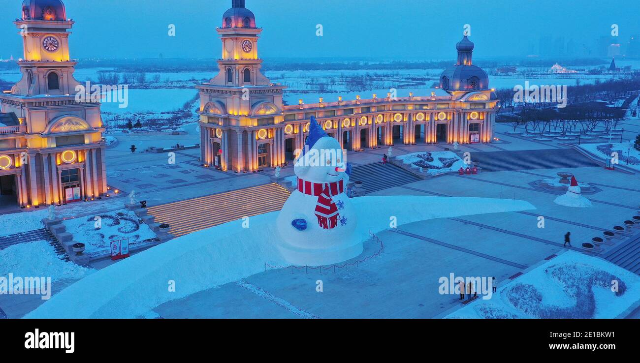 Un enorme pupazzo di neve con l'altezza di 18 metri si erge Di fronte all'ingresso principale, simile a un castello, di Harbin Music Park e attira l'attenzione dei turisti Foto Stock
