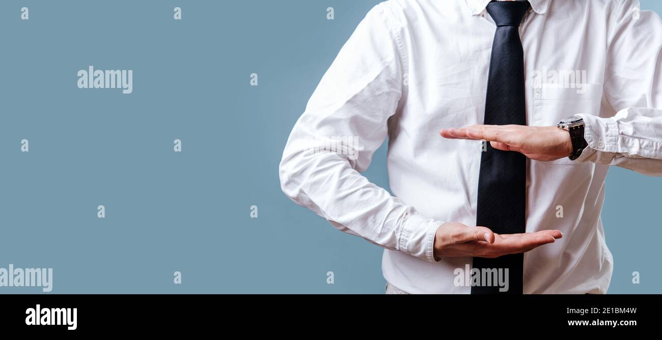 Le mani dell'uomo d'affari in una camicia e legare presentano qualcosa Foto Stock