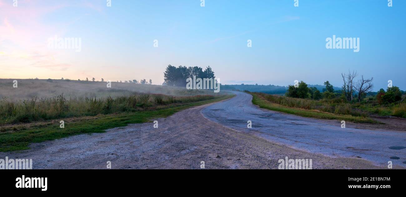 Paesaggio estivo frizzante con strada rurale all'alba Foto Stock