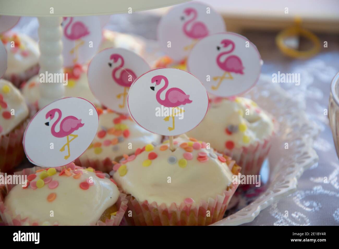 Primo piano di cupcake fatti in casa con decorazione rosa dei bastoni di fenicottero su un piatto, concetto di festa, dolci per la celebrazione di compleanno, fuoco selettivo Foto Stock