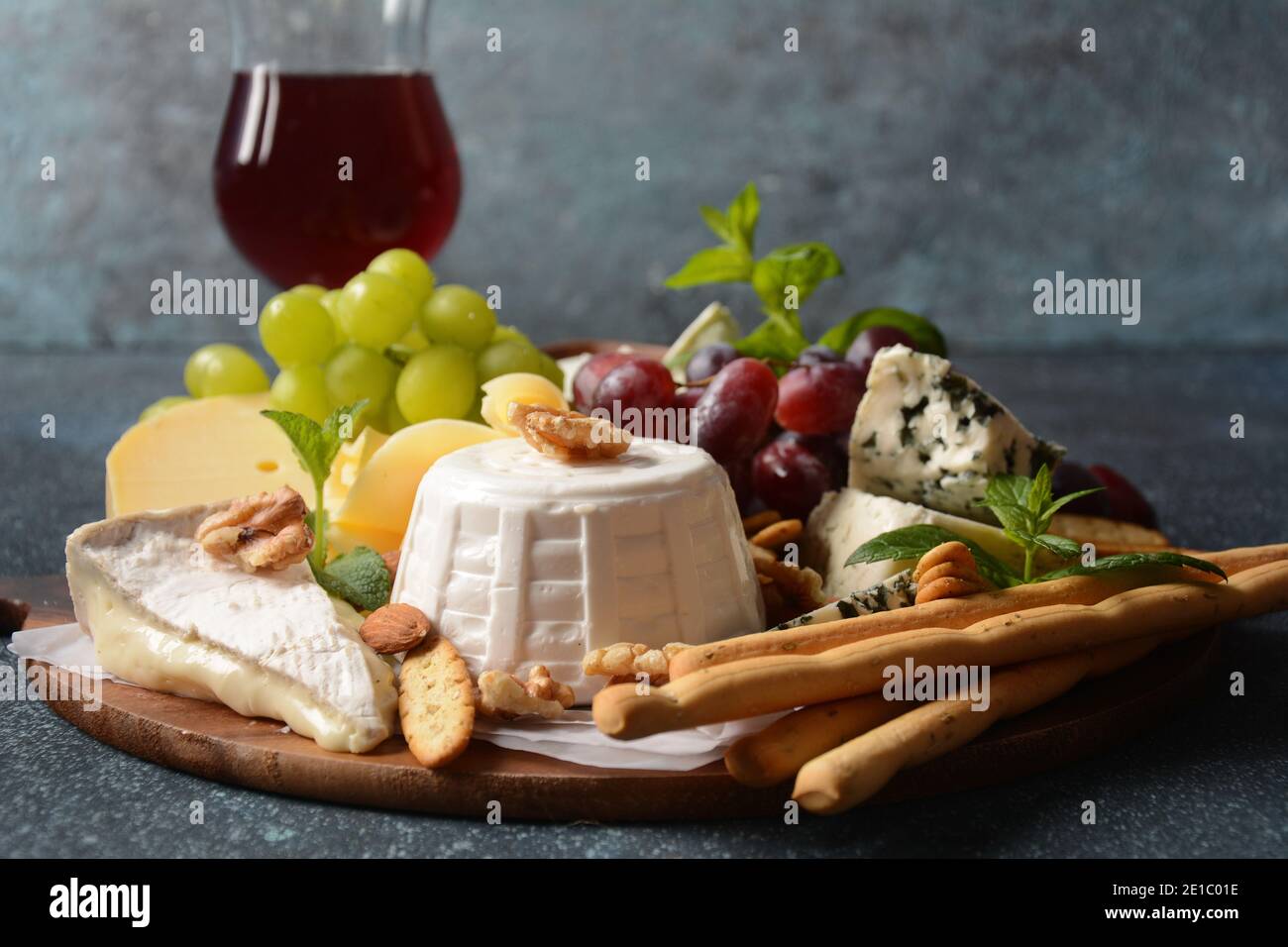 Piatto di formaggi con formaggi assortiti, uva, noci e spuntini. Antipasto di formaggio italiano e francese. Tradizionale Shavuot ebraico concetto di cibo di vacanza Foto Stock
