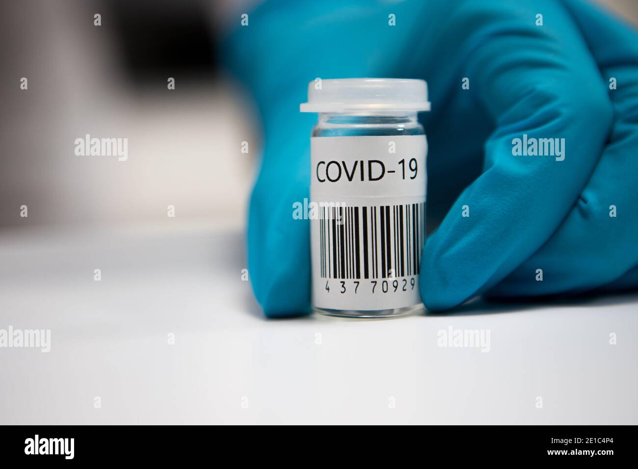 Dose di vaccinazione con coronavirus pronta per l'immunizzazione. Medico con le mani guanto che tiene una fiala di vetro di vaccino covid-19 Foto Stock