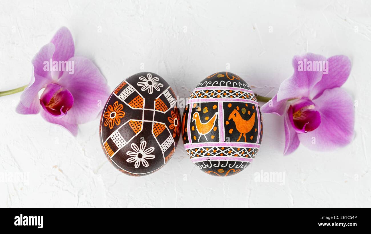 Uova di Pasqua fatte a mano. Pysanka Ucraina decorata con tecnica di tintura cerata-resistente con fiori su sfondo bianco Foto Stock