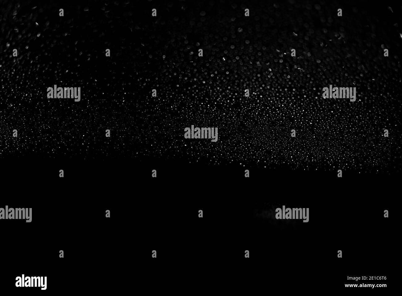 Gocce di pioggia su fondo nero in vetro da vicino. Gocce d'acqua texture nera. Foto Stock