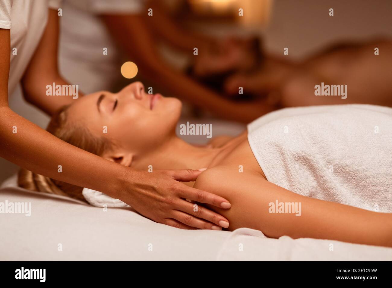 Donna che gode di un massaggio durante il trattamento di bellezza delle Coppie che si trova presso la Spa Foto Stock